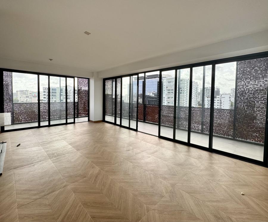 Main living area with herringbone floors and a glass wall overlooking Piantini